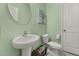 Mint green powder room with pedestal sink, modern toilet and neutral accents at 314 Beverly Dr, Ladson, SC 29456
