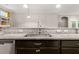 Close-up of the kitchen sink with granite countertops and dark cabinetry at 314 Beverly Dr, Ladson, SC 29456
