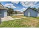 Fenced backyard with lawn and walkway to rear detached garage and blue skies at 317 Pimpernel St, Summerville, SC 29483