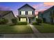 Charming two-story home with a well-manicured lawn and inviting front porch in a suburban neighborhood at dusk at 317 Pimpernel St, Summerville, SC 29483