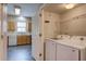 Adjacent laundry room with washer, dryer, and shelving with access from the kitchen at 317 Pimpernel St, Summerville, SC 29483
