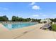 Side view of the community pool, umbrellas, and lounge chairs on a sunny day at 317 Pimpernel St, Summerville, SC 29483