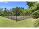 Well-maintained tennis court surrounded by a secure fence and lush greenery at 317 Pimpernel St, Summerville, SC 29483