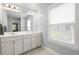 Bright bathroom featuring double sink vanity, ample lighting, and tiled floors at 3191 Moonlight Dr, Charleston, SC 29414