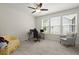Bright, carpeted bedroom with a ceiling fan and a view of the backyard through three windows at 3191 Moonlight Dr, Charleston, SC 29414