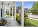 Inviting front porch features white columns and views of a beautifully landscaped yard at 3191 Moonlight Dr, Charleston, SC 29414