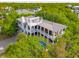 Gorgeous aerial view of a luxury home featuring lush landscaping, a private pool, and multiple outdoor living spaces at 3301 Palm Blvd, Isle of Palms, SC 29451