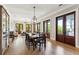 Well-lit dining room featuring a large wooden table, chairs, and multiple doors leading outside at 3301 Palm Blvd, Isle of Palms, SC 29451