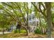 Beautiful two-story home with covered patios, lush greenery, and a charming exterior design at 3301 Palm Blvd, Isle of Palms, SC 29451