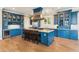 Bright kitchen featuring blue cabinets, a kitchen island, and stainless steel appliances at 3301 Palm Blvd, Isle of Palms, SC 29451