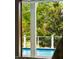 View of the pool and outdoor area from inside the home through the french doors at 3301 Palm Blvd, Isle of Palms, SC 29451