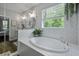 Bright bathroom featuring a soaking tub with large window and glass enclosed shower at 3361 Olivia Marie Ln, Johns Island, SC 29455