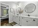 A white bathroom with double vanity and framed mirrors opening into bedroom at 3361 Olivia Marie Ln, Johns Island, SC 29455
