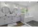 Bright bathroom with white cabinets, double sinks, and a glass-enclosed shower/tub combination at 3361 Olivia Marie Ln, Johns Island, SC 29455