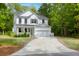 Beautiful two-story white home with a well-manicured lawn and a long driveway leading to an attached two-car garage at 3361 Olivia Marie Ln, Johns Island, SC 29455