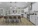 Bright kitchen featuring white cabinets, a large island with bar seating, stainless steel appliances and laminate floors at 3361 Olivia Marie Ln, Johns Island, SC 29455