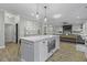 Kitchen island with microwave, white cabinets, pendant lighting, and view of open-concept living area at 3361 Olivia Marie Ln, Johns Island, SC 29455