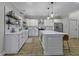 Open kitchen with a large center island, stainless steel appliances, white subway tile backsplash, and wooden floors at 3361 Olivia Marie Ln, Johns Island, SC 29455