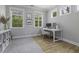 Modern home office with ample natural light, a white desk, and a stylish area rug at 3361 Olivia Marie Ln, Johns Island, SC 29455