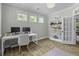 Well-lit office space featuring white furniture, a built-in bookshelf, and hardwood floors at 3361 Olivia Marie Ln, Johns Island, SC 29455