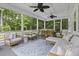 Serene screened-in porch furnished with comfortable lounge seating and a rustic dining table at 3361 Olivia Marie Ln, Johns Island, SC 29455