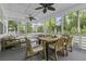 Relax on this screened porch with comfortable seating, wood table, and peaceful green views at 3361 Olivia Marie Ln, Johns Island, SC 29455