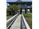 Charming elevated home with a wooden walkway and lush landscaping at 3807 Scott Creek Dr, Edisto Island, SC 29438