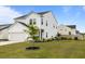 Beautifully landscaped front yard with green grass and vibrant flower beds surrounding a small tree at 401 Carrara Dr, Summerville, SC 29486