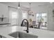 Modern kitchen featuring stainless sink, white countertops and cabinets, and a dining area with ample natural light at 401 Carrara Dr, Summerville, SC 29486