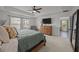 Bright main bedroom featuring a tray ceiling, a ceiling fan, a comfortable bed, and ample natural light from large windows at 401 Carrara Dr, Summerville, SC 29486