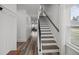 Inviting staircase with wood treads and natural light filtering in from a large window adds to the charm of the home at 401 Carrara Dr, Summerville, SC 29486