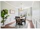 Bright dining room with hardwood floors, elegant wainscoting, and a rustic wooden table with seating for six at 4024 Exploration Rd, Ladson, SC 29456