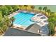 An aerial shot of a large community swimming pool featuring palm trees, lounge chairs, and an adjacent pool house at 4024 Exploration Rd, Ladson, SC 29456