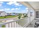 Exterior view from a porch with white railings overlooking a quiet street and a neighborhood with well-maintained lawns at 4024 Exploration Rd, Ladson, SC 29456