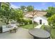 Outdoor space with a concrete patio, seating, lush greenery, and a white garage at 404 Forsythia Ave, Summerville, SC 29483