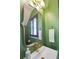 Stylish powder room with a gold swan faucet, decorative mirror and bright green walls at 404 Forsythia Ave, Summerville, SC 29483