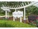 Close up of the White Gables entrance sign, framed by lush greenery and mature trees, creating a serene welcome at 404 Forsythia Ave, Summerville, SC 29483