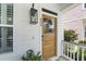 Eye-catching stained wood front door, charming exterior lighting, white siding and blue ceiling adds character and curb appeal at 404 Forsythia Ave, Summerville, SC 29483