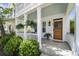 Welcoming front porch with ferns, fresh landscaping, stained wood door, and blue ceiling providing southern charm at 404 Forsythia Ave, Summerville, SC 29483