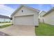 A white garage with a concrete driveway and green grass at 404 Forsythia Ave, Summerville, SC 29483