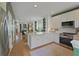 Bright open-concept kitchen with white cabinets, marble countertops, stainless steel appliances, and hardwood flooring throughout at 404 Forsythia Ave, Summerville, SC 29483