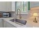 Stylish kitchen sink features a modern faucet, white cabinets, marble countertops, and window with natural light at 404 Forsythia Ave, Summerville, SC 29483