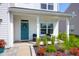 Cozy front porch showcasing a teal door with a wreath, seating, and lush landscaping in a charming setting at 408 Trevi Ln, Summerville, SC 29486