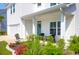 Inviting front porch with outdoor seating, colorful flowerbeds, and a charming wreath on the teal-colored front door at 408 Trevi Ln, Summerville, SC 29486