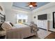 Bright main bedroom features a tray ceiling, ceiling fan, a large window, and wood flooring at 408 Trevi Ln, Summerville, SC 29486