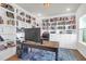 Bright home office with wall-to-wall bookshelves, a comfortable desk, and ample natural light at 408 Trevi Ln, Summerville, SC 29486