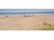 Scenic beach view with clear skies, gentle waves, and people enjoying the sun at 412 Palmetto Blvd, Edisto Island, SC 29438