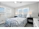 Inviting bedroom with two windows, a bed with floral bedding, and bedside tables at 412 Palmetto Blvd, Edisto Island, SC 29438