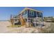 Beautiful blue beach house featuring stairs, a large deck, and coastal charm at 412 Palmetto Blvd, Edisto Island, SC 29438