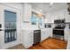 Well-lit kitchen with modern appliances, white cabinetry, and a door leading to the balcony at 412 Palmetto Blvd, Edisto Island, SC 29438